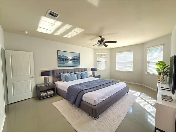 a bedroom with a large bed and a chandelier