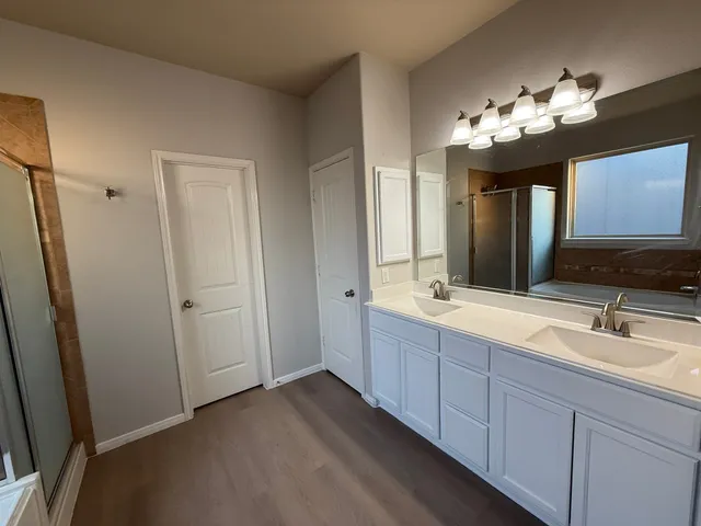 a spacious bathroom with a double vanity sink and a mirror