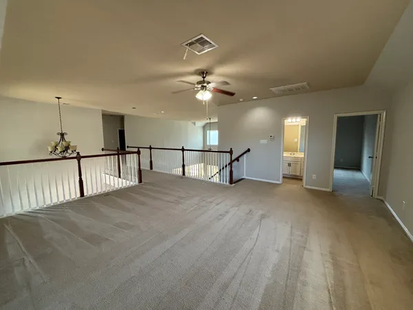 a view of a livingroom with a ceiling fan a window and a chandelier