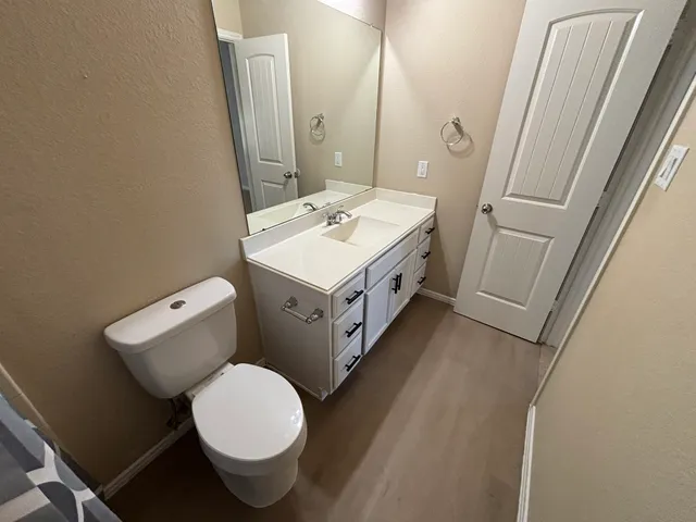 a bathroom with a toilet sink and mirror
