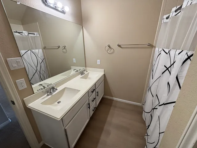 a bathroom with a double vanity sink and a mirror