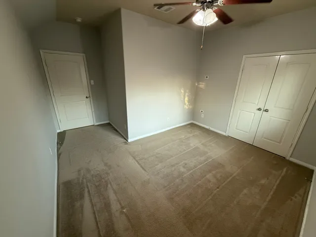 an empty room with a chandelier fan