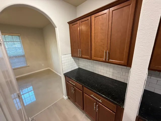 a kitchen with granite countertop cabinets and black appliances