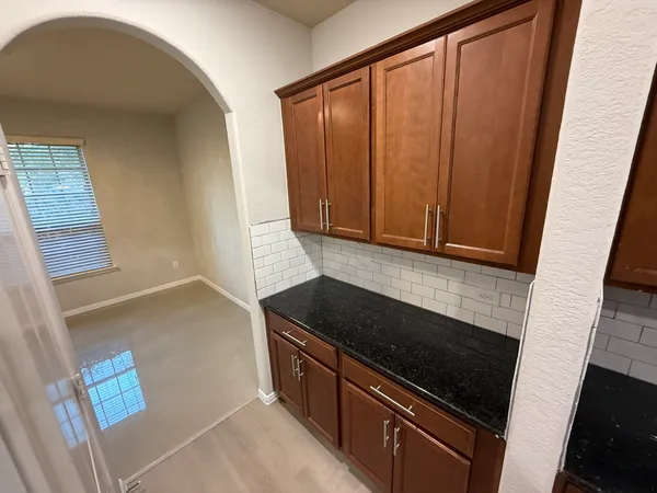 a kitchen with granite countertop cabinets and black appliances