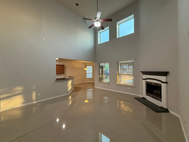 a living room with a fireplace furniture and a ceiling fan