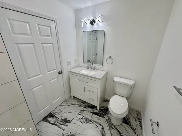 a bathroom with a toilet sink and mirror