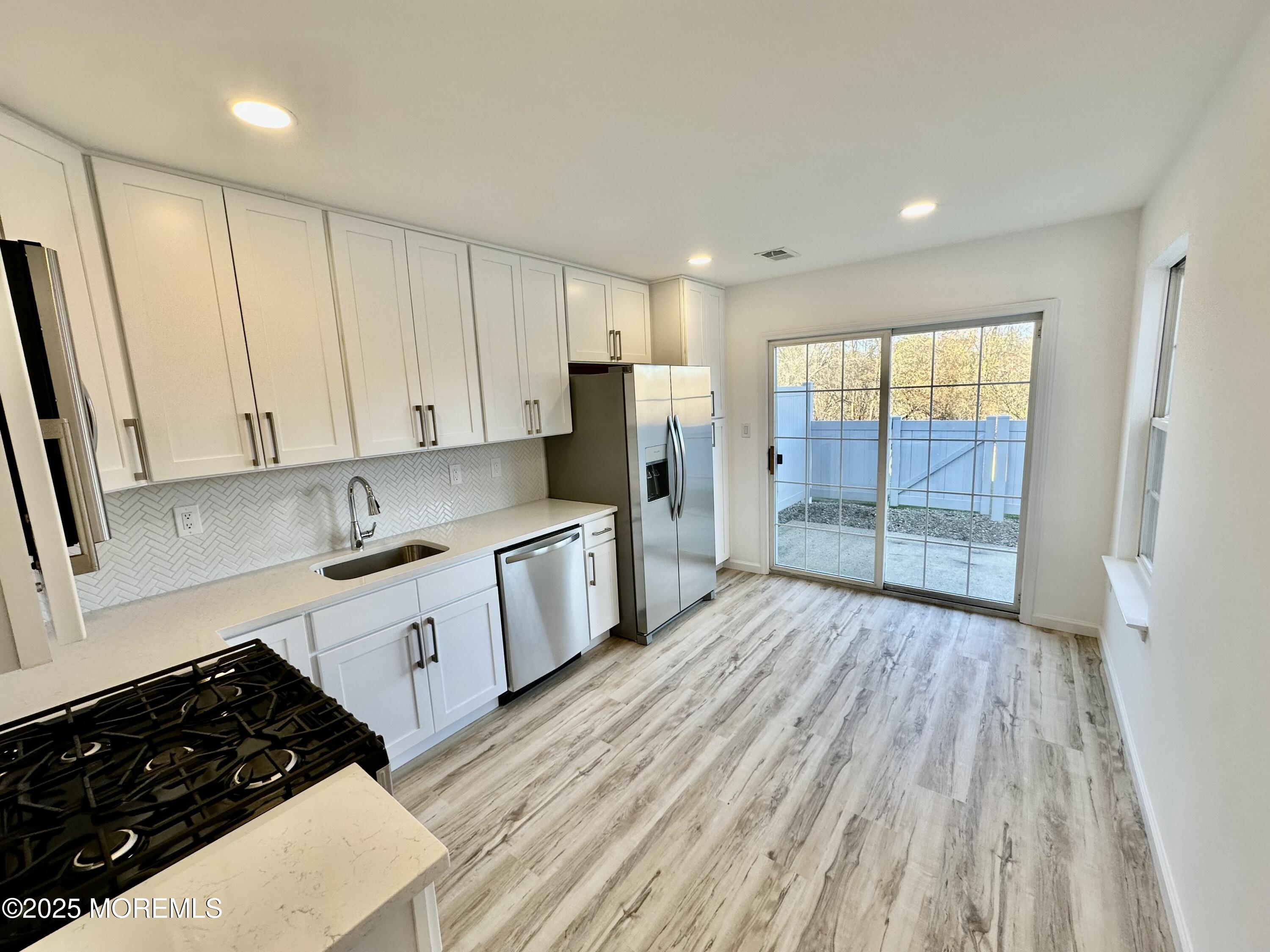 51 Picket Place Freehold, NJ 07728 - Photo 10 of 47 a kitchen with wooden floors and appliances
