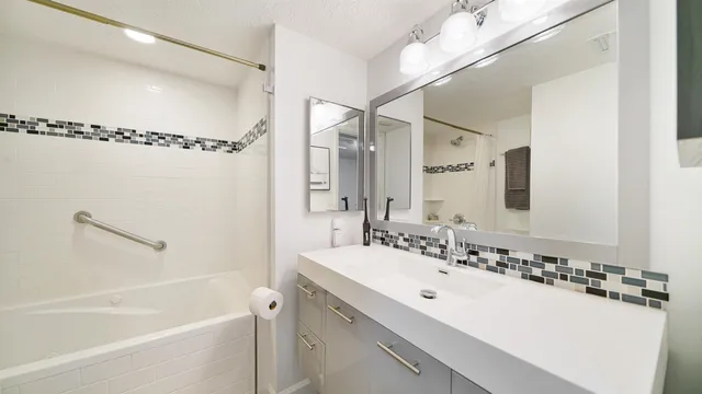 a bathroom with a granite countertop shower sink and vanity