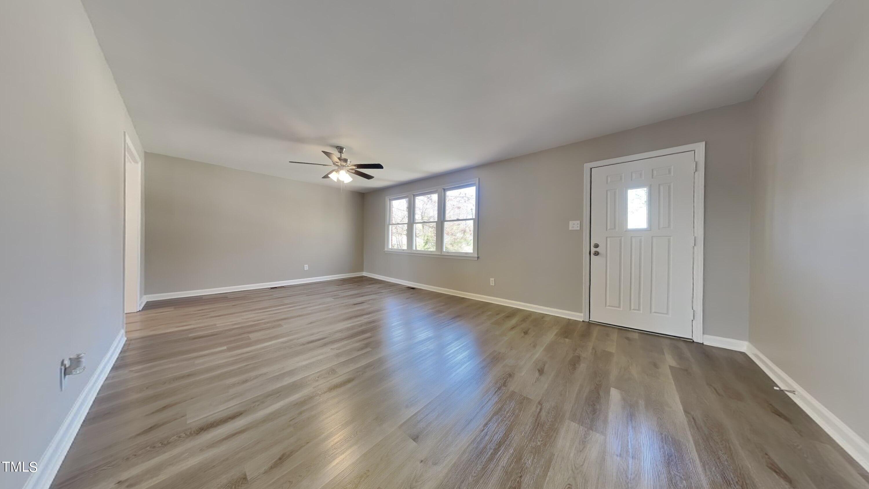 2028 Timber Drive Raleigh, NC 27604 - Photo 3 of 13 a view of an empty room with wooden floor and window