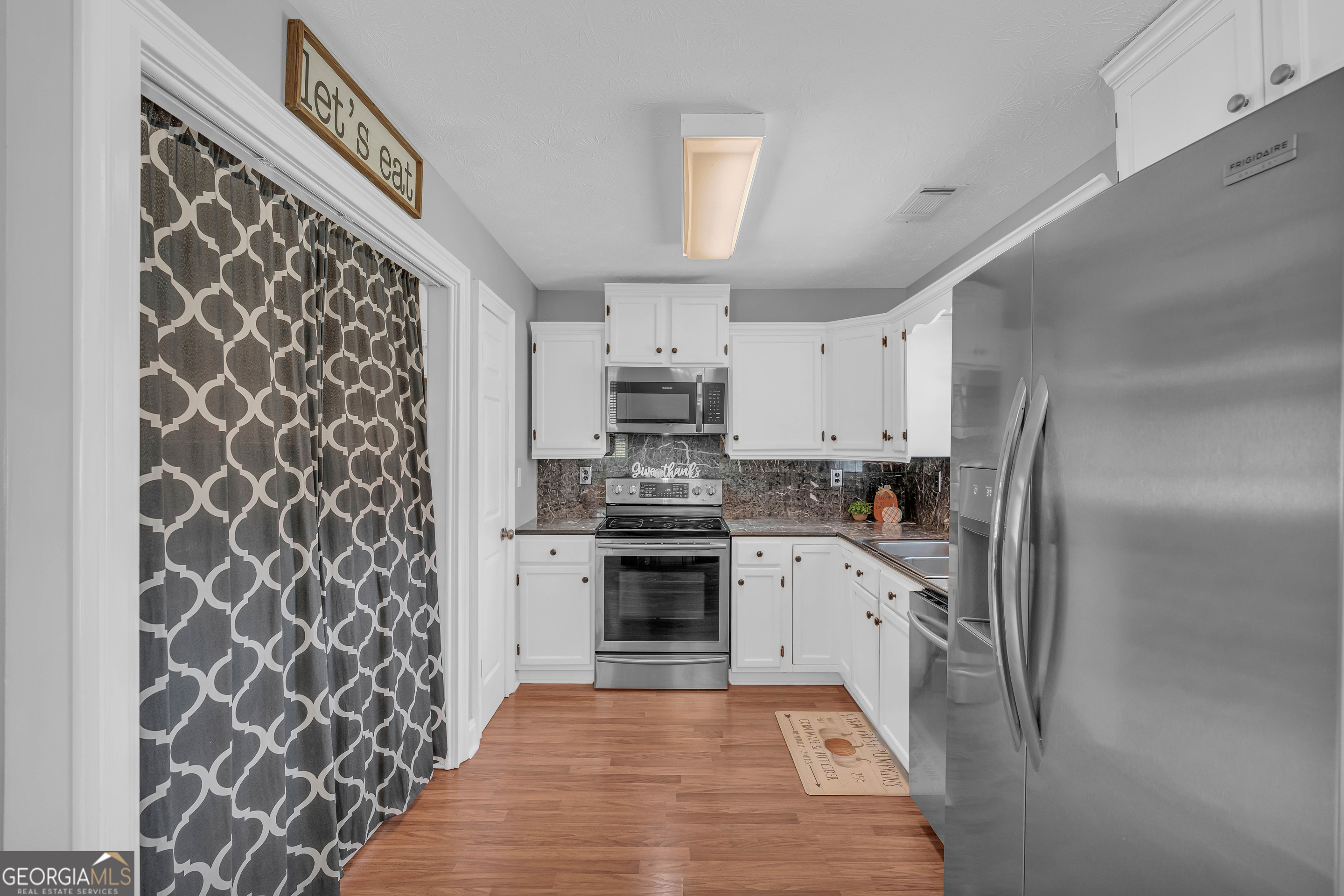 809 Parker Court Monroe, GA 30656 - Photo 16 of 55 a kitchen with granite countertop a refrigerator and a stove top oven