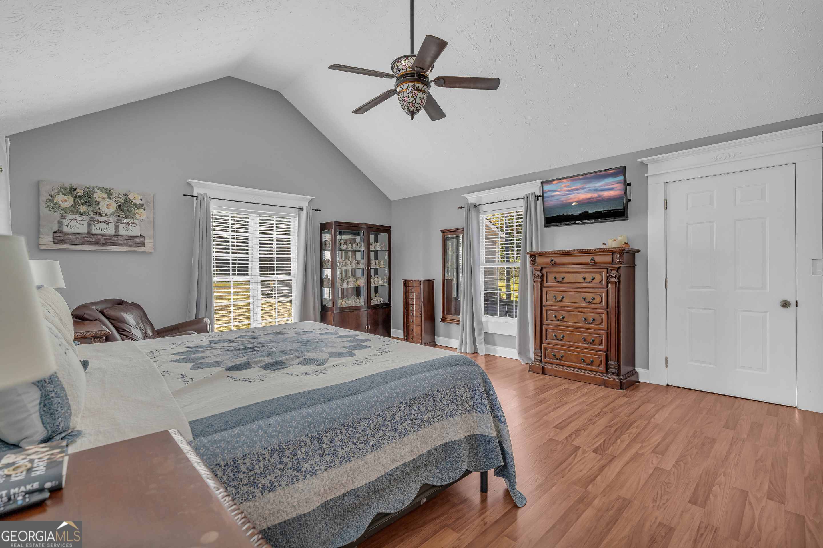 809 Parker Court Monroe, GA 30656 - Photo 25 of 55 a bedroom with a bed and a dresser with wooden floor