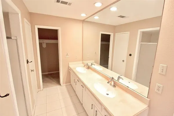 a spacious bathroom with a double vanity sink and a mirror