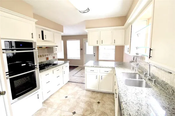 a kitchen with stainless steel appliances kitchen island granite countertop a stove a sink and a refrigerator