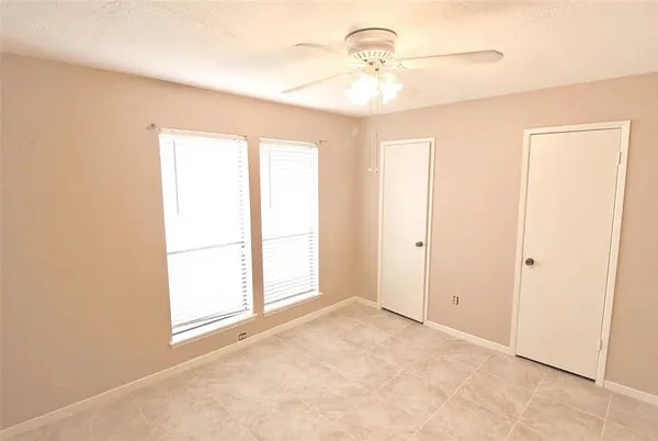 an empty room with windows and closet