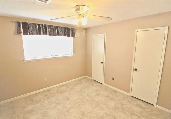 a view of an empty room with window and a chandelier