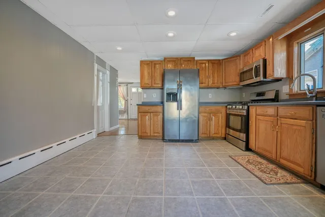 a kitchen with stainless steel appliances granite countertop a refrigerator a stove top oven and sink