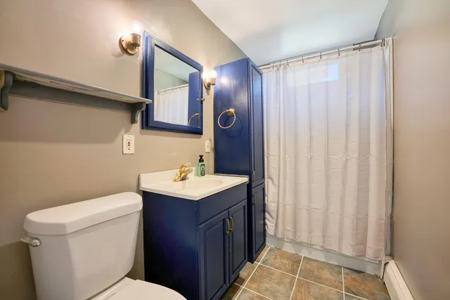 a bathroom with a sink a toilet and shower curtain
