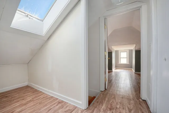 a view of a hallway with wooden floor and closet