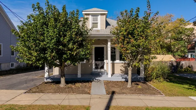 a front view of a house with a tree