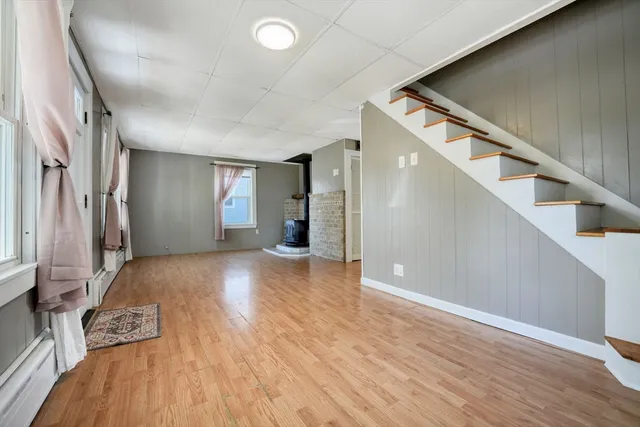 a view of a livingroom with wooden floor and stairs