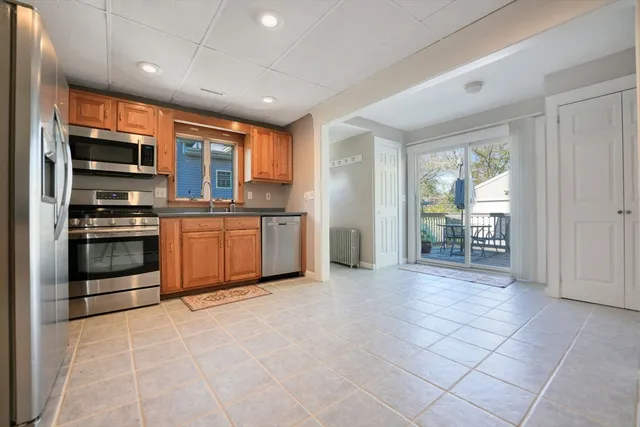 a view of kitchen with stainless steel appliances granite countertop a stove top oven a sink dishwasher and a refrigerator with wooden floor