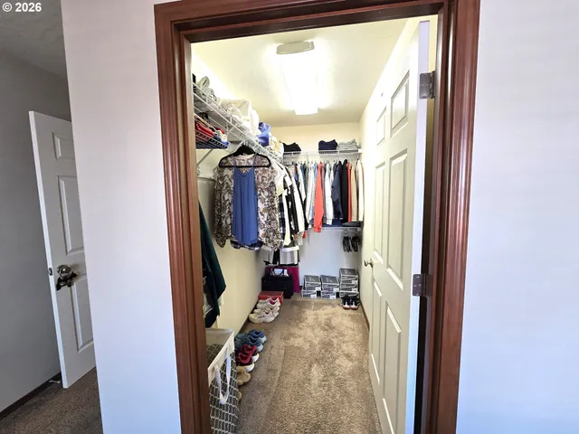 a view of walk in closet with clothes and shoes