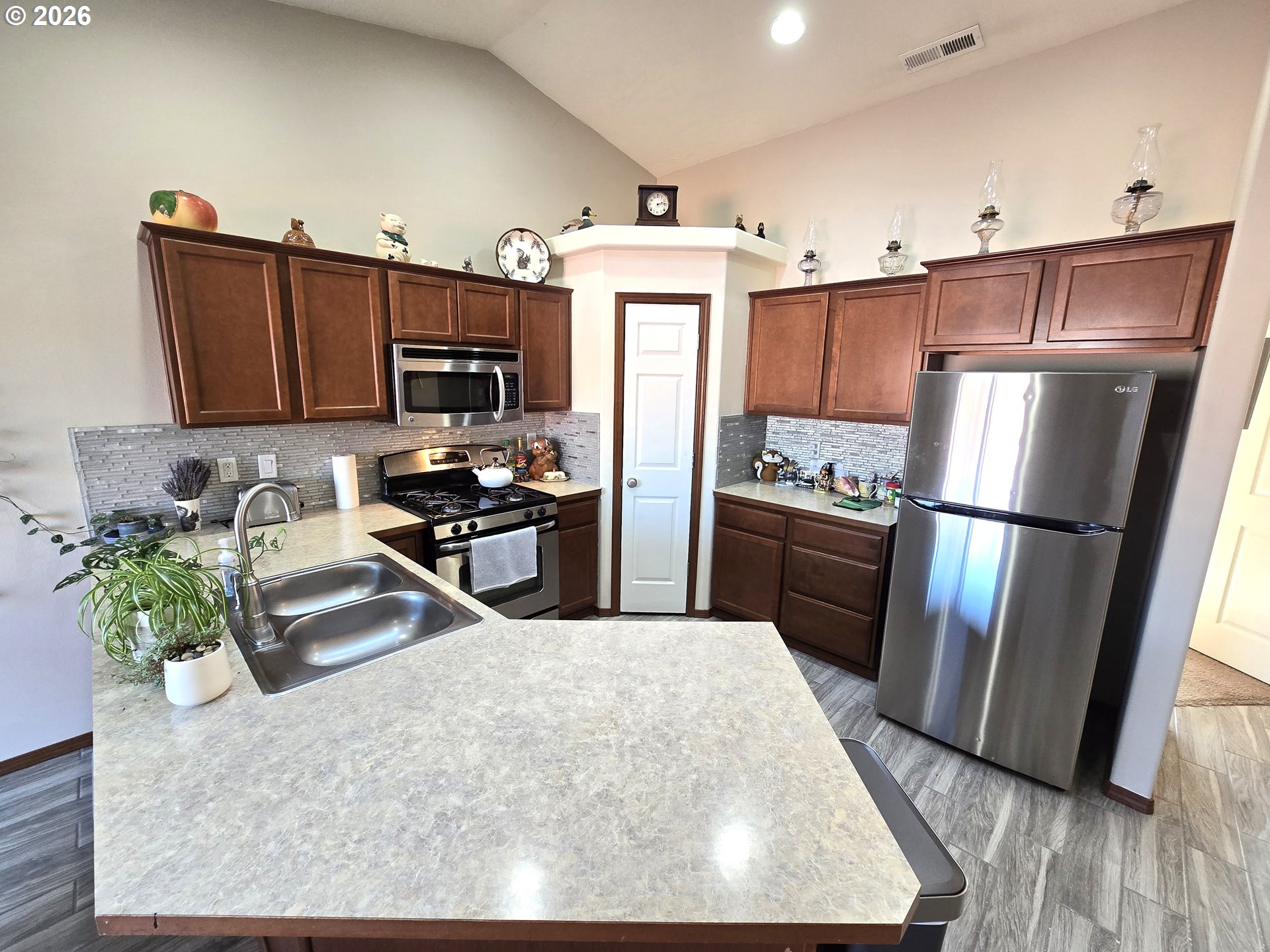 240 West Moore Avenue Hermiston, OR 97838 - Photo 3 of 19 a kitchen with granite countertop a refrigerator a sink a stove a microwave and wooden floor