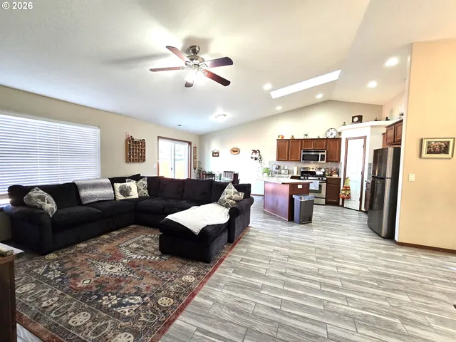 a living room with furniture kitchen view and a refrigerator
