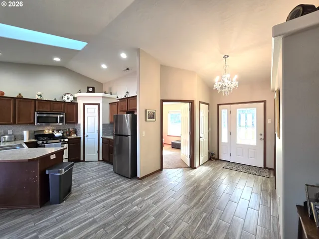 a view of a kitchen with refrigerator and wooden floor