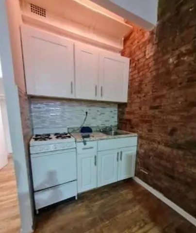 a kitchen with stainless steel appliances granite countertop a sink stove and cabinets