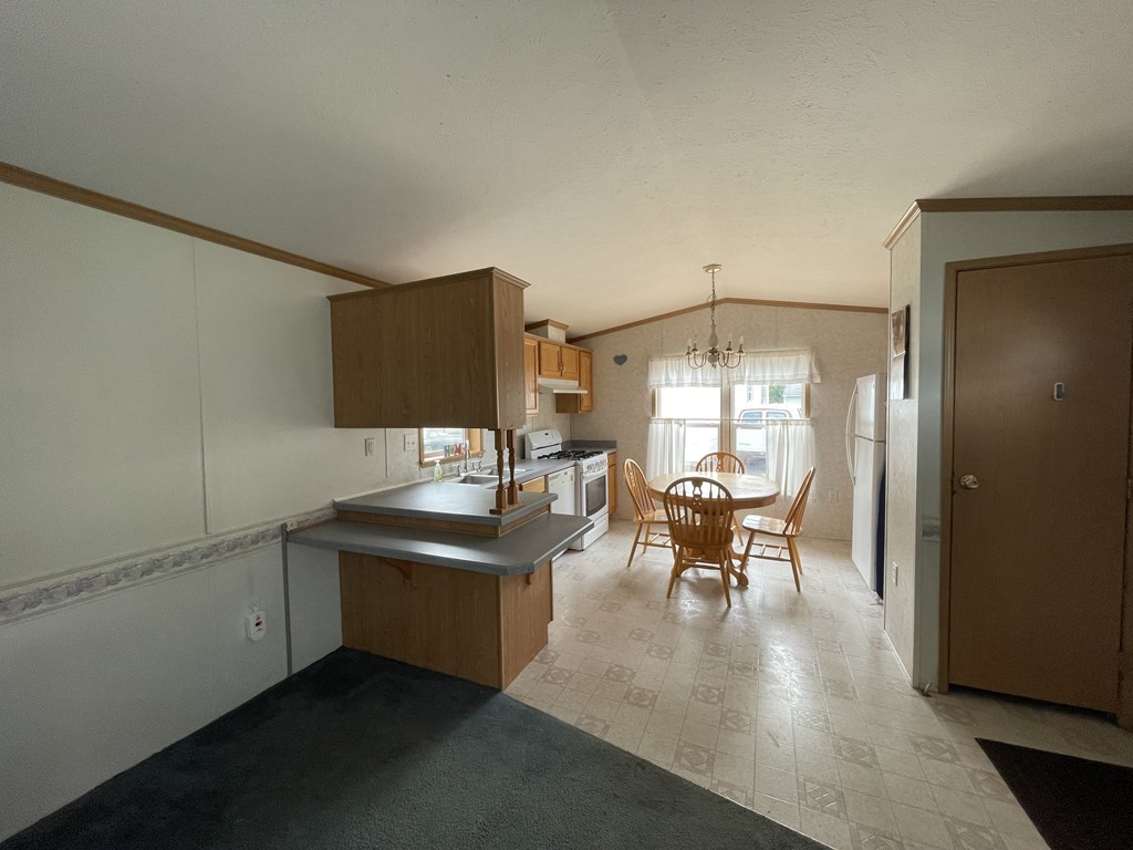 268 Palmer Road, Unit 12 Monson, MA 01057 - Photo 8 of 15 a kitchen with a table chairs and white walls
