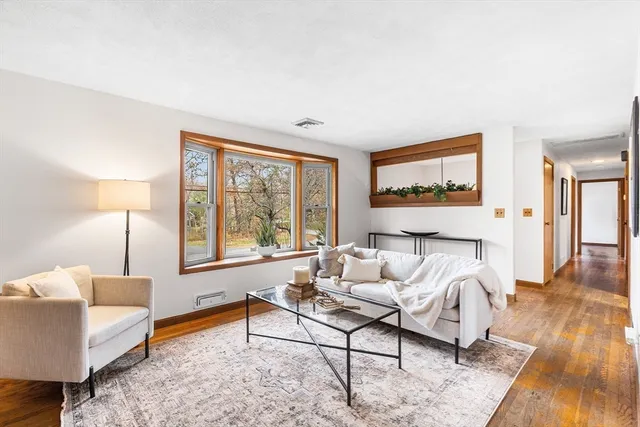 a living room with furniture a fireplace and a large window