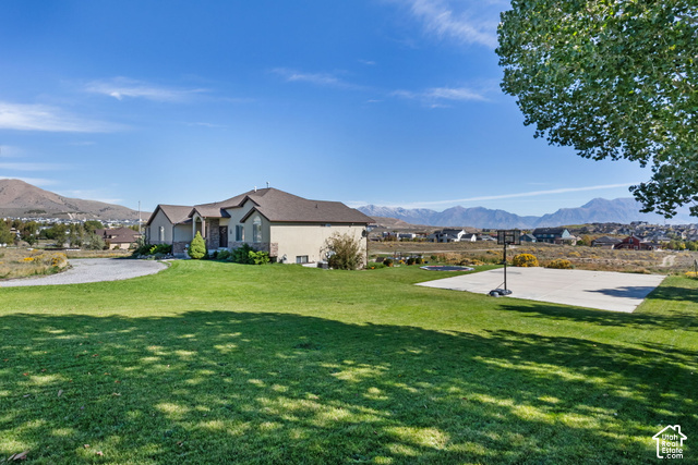 9044 North Cedar Pass Road Eagle Mountain, UT 84005 - Photo 6 of 63 Expansive lawn with a concrete sports court and mountain backdrop