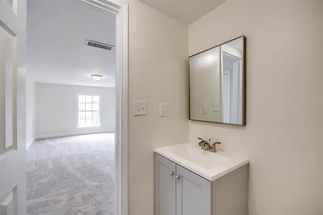 a bathroom with a sink a mirror and a vanity