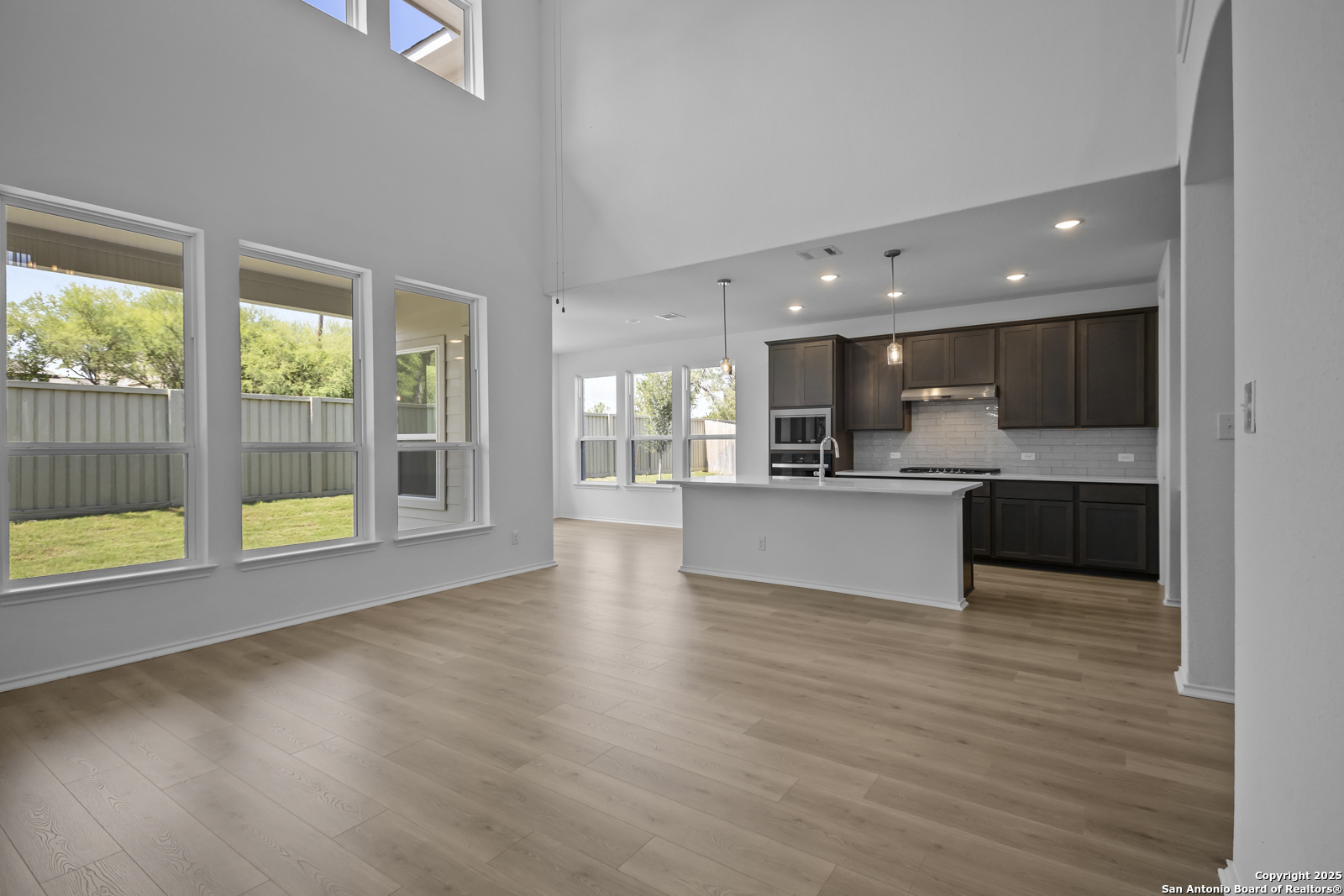 517 Foxtail Canyon Cibolo, TX 78108 - Photo 15 of 38 a view of kitchen with kitchen island a sink wooden floor and a large window