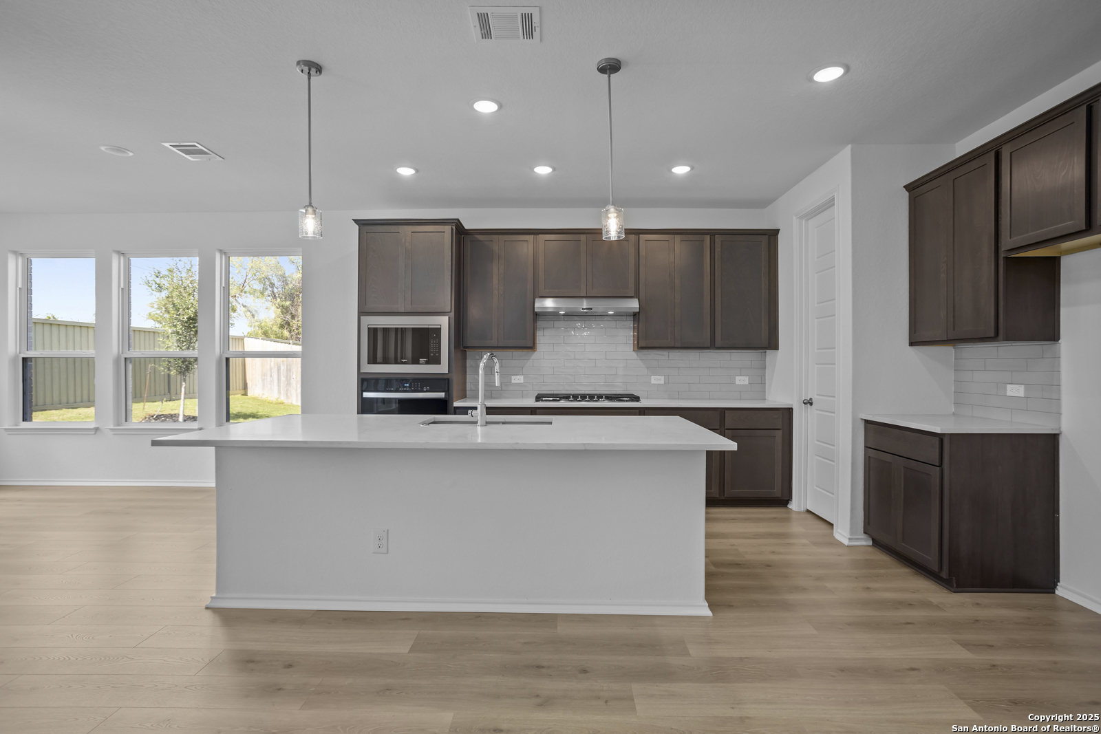 517 Foxtail Canyon Cibolo, TX 78108 - Photo 8 of 38 a large kitchen with kitchen island granite countertop a large counter top stainless steel appliances and cabinets