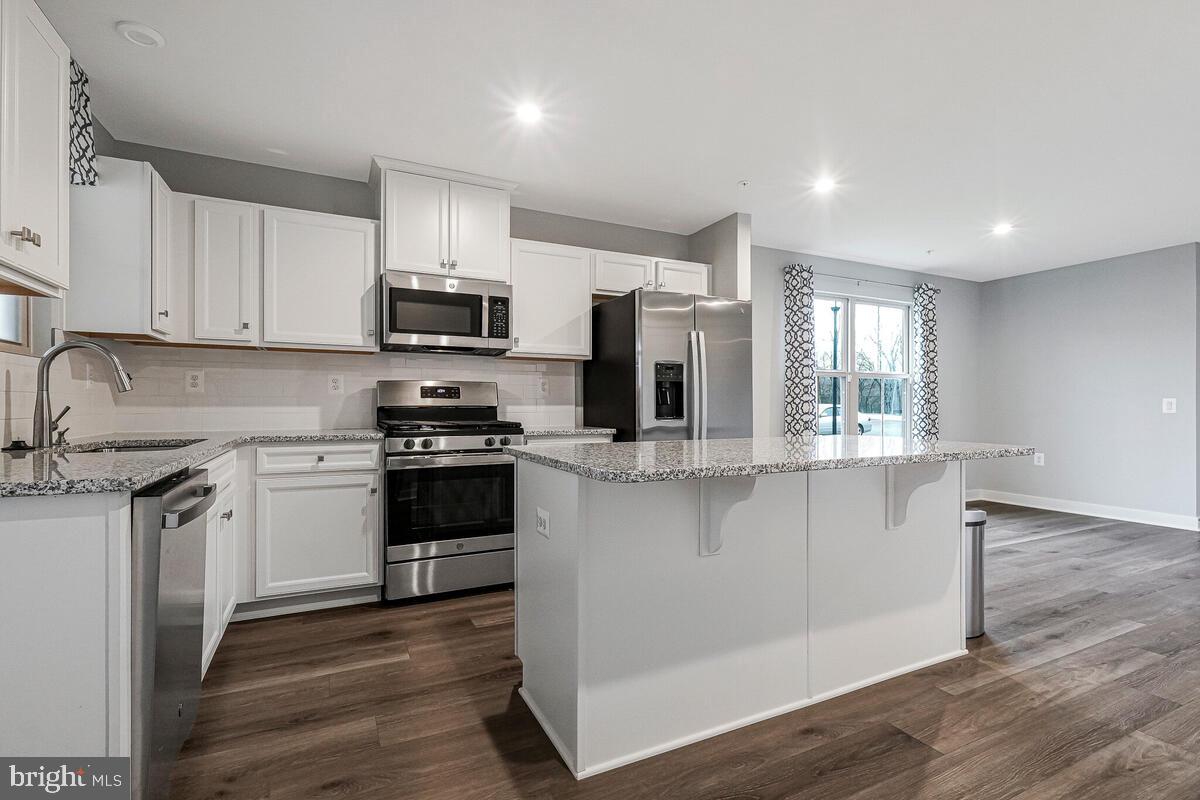 14380 Longhouse Loop Brandywine, MD 20613 - Photo 11 of 35 a kitchen with stainless steel appliances a stove sink microwave and cabinets