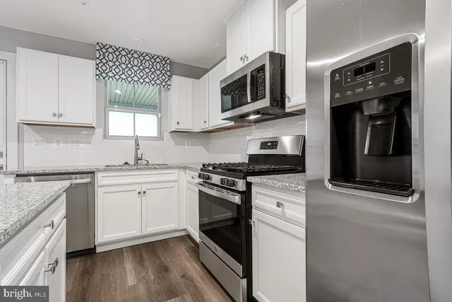 a kitchen with stainless steel appliances granite countertop a stove microwave and sink