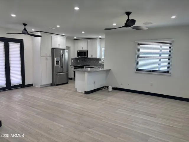 a view of kitchen with stainless steel appliances refrigerator stove microwave and cabinets