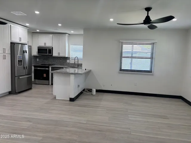 a kitchen with stainless steel appliances kitchen island granite countertop a stove and a refrigerator