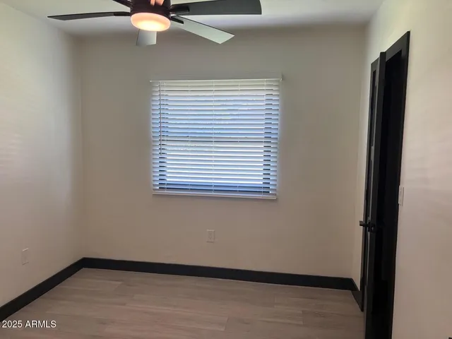 a view of a small space with wooden floor and a window