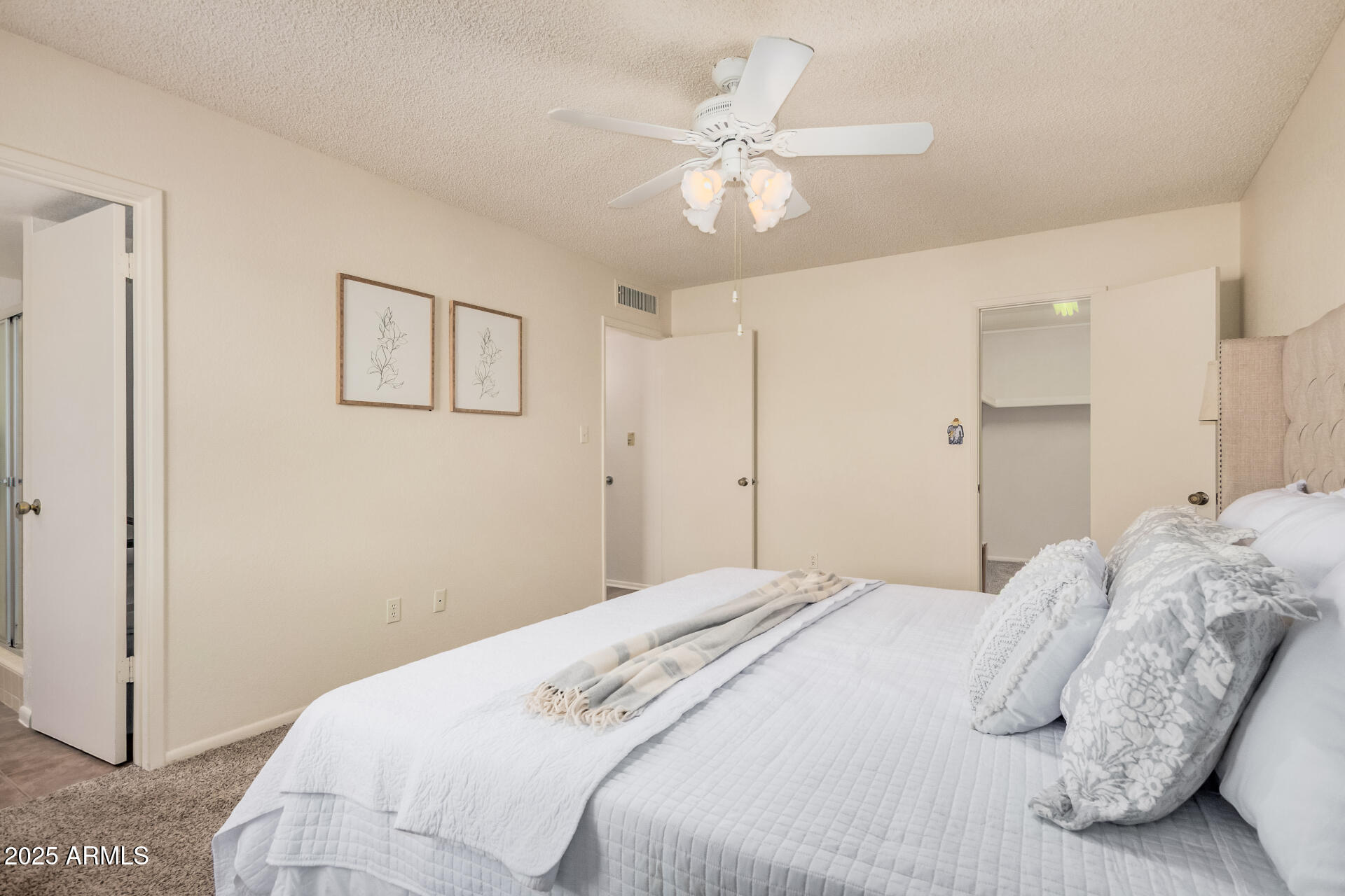 10512 West Ruth Avenue Peoria, AZ 85345 - Photo 13 of 33 a bedroom with a large bed and a chandelier
