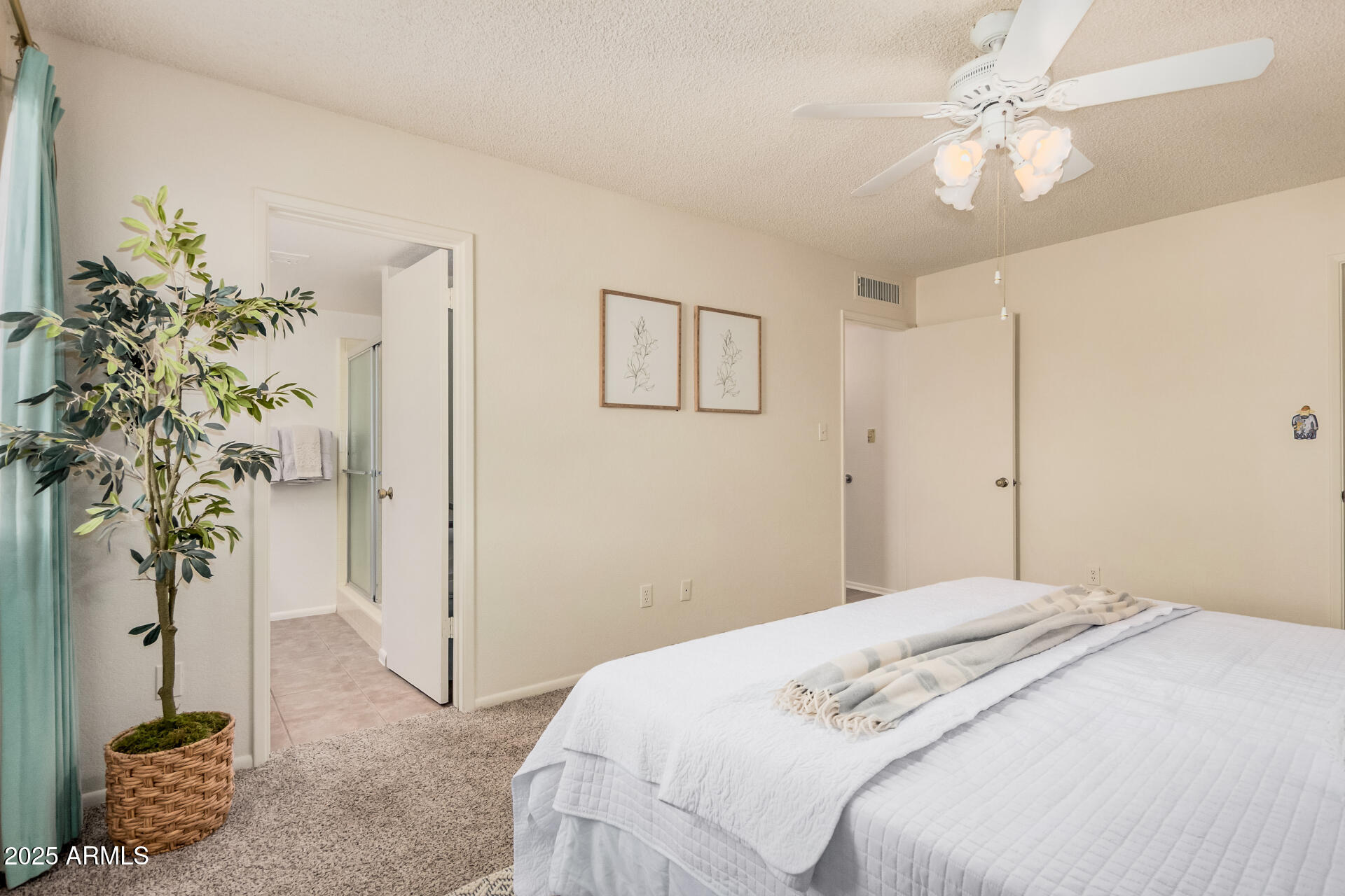 10512 West Ruth Avenue Peoria, AZ 85345 - Photo 14 of 33 a bedroom with a large bed and a chandelier