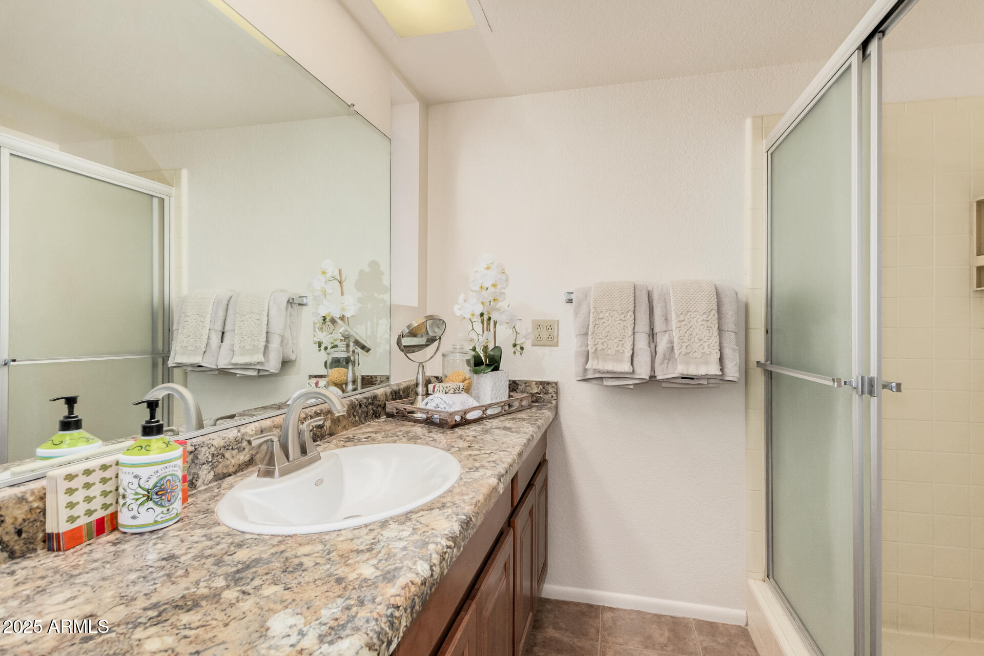 10512 West Ruth Avenue Peoria, AZ 85345 - Photo 16 of 33 a bathroom with a granite countertop sink and a mirror