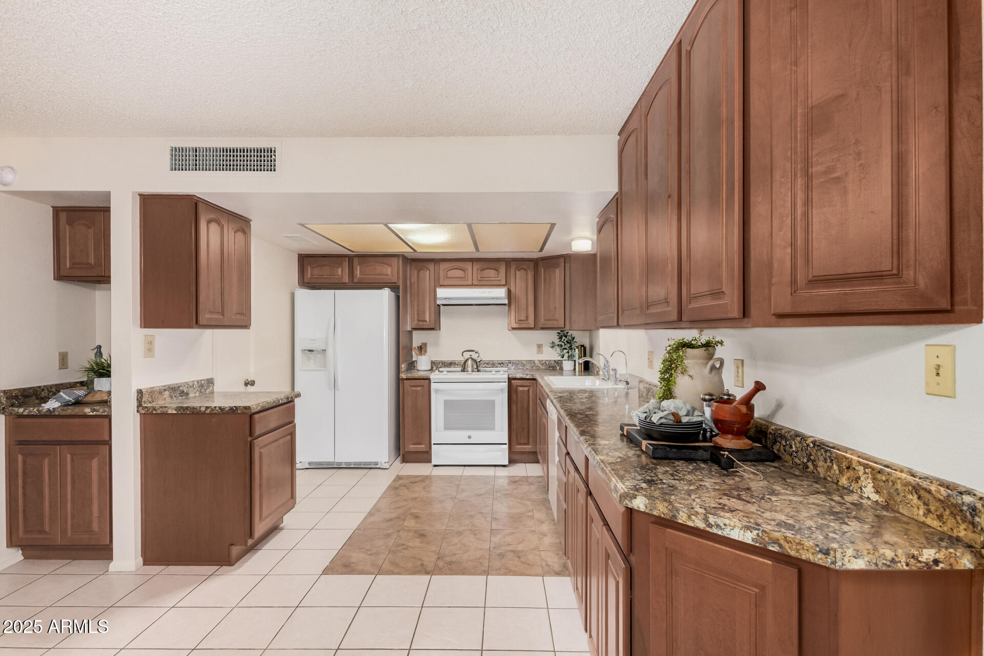 10512 West Ruth Avenue Peoria, AZ 85345 - Photo 7 of 33 a kitchen with granite countertop a stove sink and cabinets