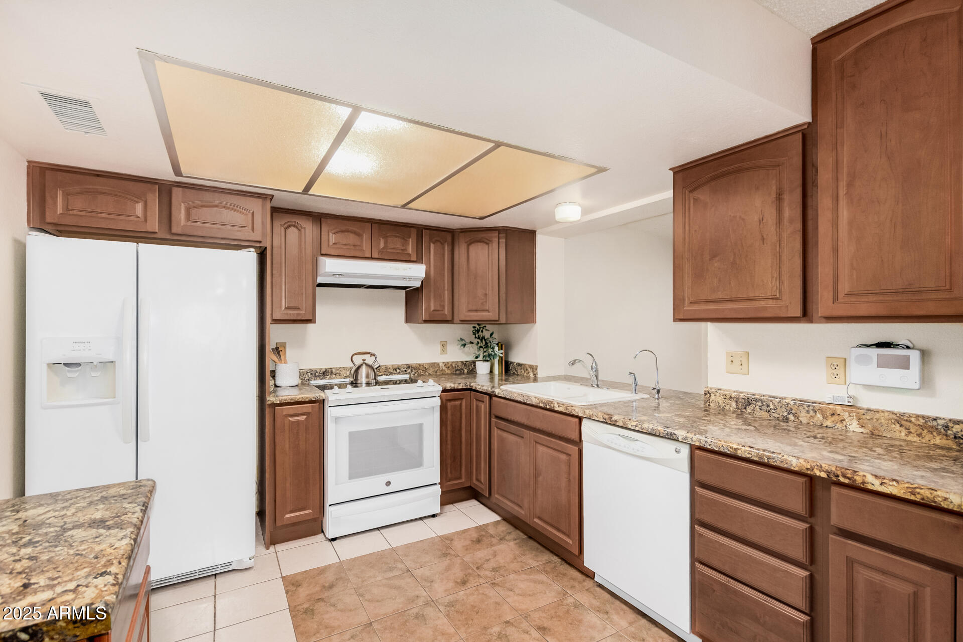 10512 West Ruth Avenue Peoria, AZ 85345 - Photo 10 of 33 a kitchen with stainless steel appliances granite countertop a sink stove and refrigerator