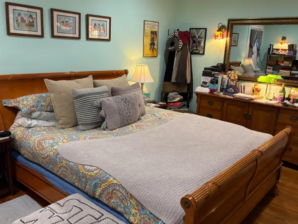 a bedroom with bed and painting on the wall