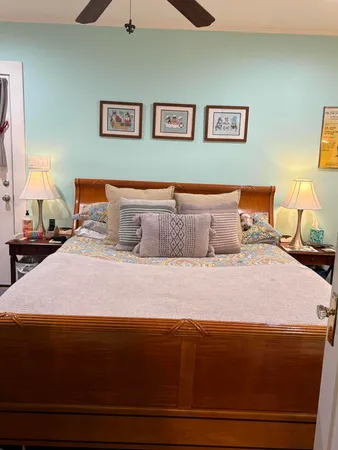 a bedroom with a bed and a lamp on dresser