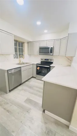 a large kitchen with stainless steel appliances wooden cabinets and a stove top oven