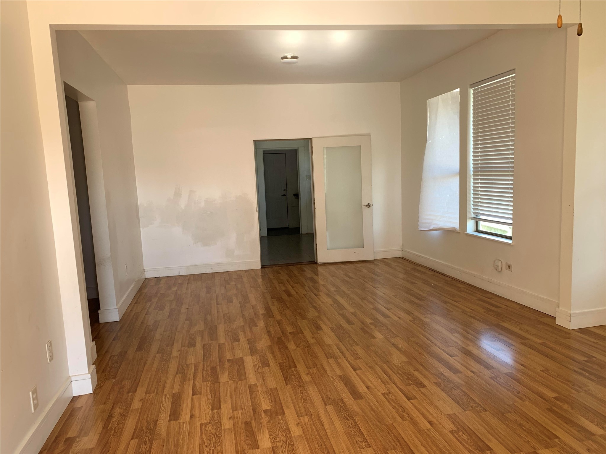206 Cosmos Street Houston, TX 77009 - Photo 2 of 14 an empty room with wooden floor and windows